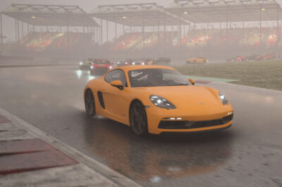 Ein orangenes Auto führt in einem Forza Motorsports-Rennen das Feld an. Es regnet und das Auto spiegelt sich auf der nassen Fahrbahn.