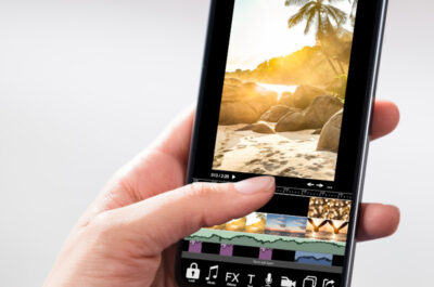 Hand die Smartphone hält bei dem das Bildschirm eine Bildbearbeitung-App anzeigt
