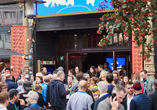 Das Theater Schmidts Tivoli während der NEXT Conference. Vor dem Theater stehen viele Menschen, viele miteinander im angeregten Austausch.