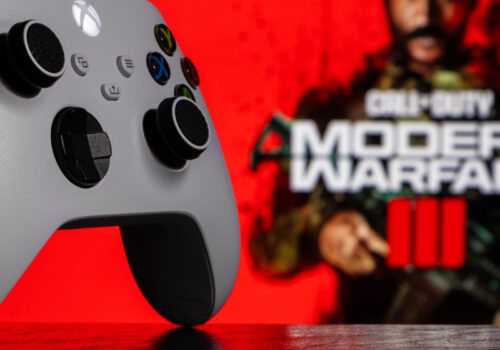 Ein Xbox Series Controller auf dem Tisch, im Hintergrund sieht man etwas verschwommen das Logo von Call of Duty: Modern Warfare 3.