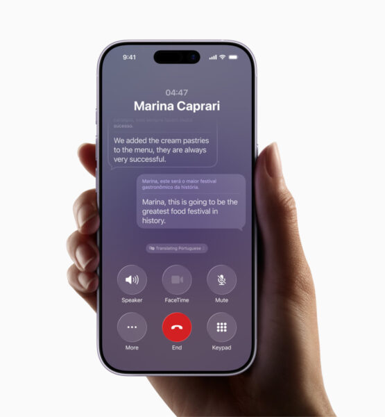 Eine Hand hält ein iPhone, auf der eine Kommunikations-App geöffnet ist, deren Nachrichten mit KI-Unterstützung ins Englische übersetzt werden.
