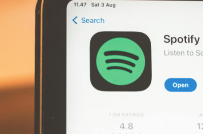 Zu sehen ist die obere Ecke eines Laptops. Geöffnet ist der Appstore mit der Spotify-App. am unteren Rand steht geschrieben "What's New?"