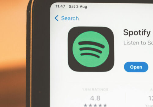 Zu sehen ist die obere Ecke eines Laptops. Geöffnet ist der Appstore mit der Spotify-App. am unteren Rand steht geschrieben "What's New?"