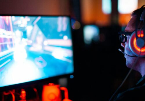 Person, die einen Computer benutzt, um ein FPS-Spiel zu spielen