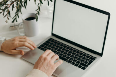 Eine Laptop steht geöffnet auf einem Tisch und wird benutzt.