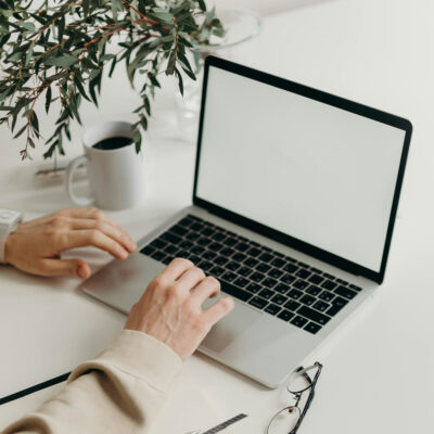 Eine Laptop steht geöffnet auf einem Tisch und wird benutzt.
