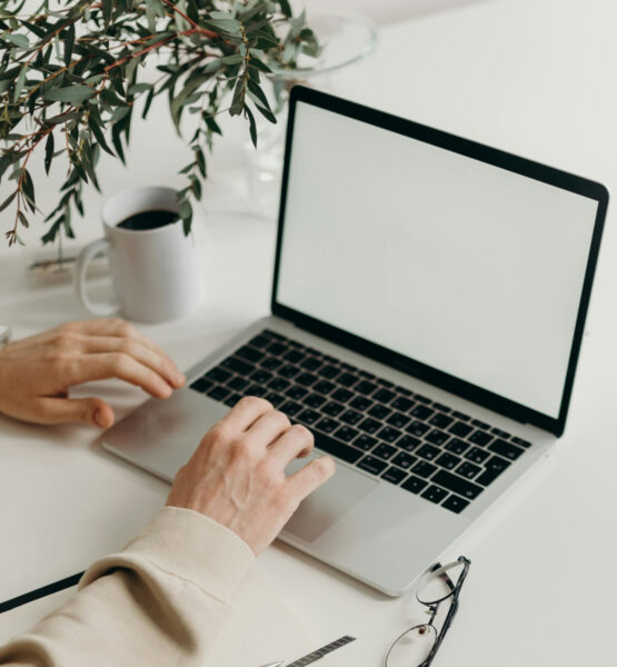 Eine Laptop steht geöffnet auf einem Tisch und wird benutzt.