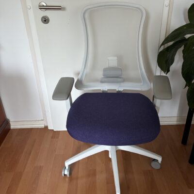 Ergonomischer Bürostuhl, Weiß und Lila, vor einer Tür