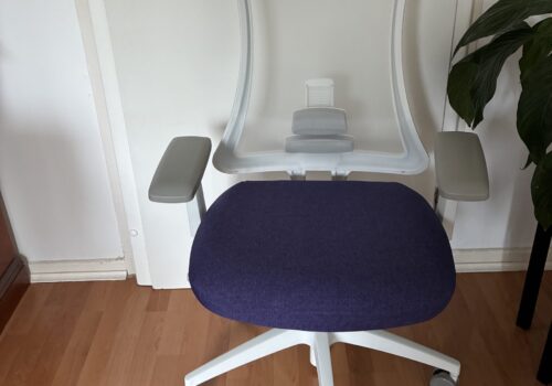 Ergonomischer Bürostuhl, Weiß und Lila, vor einer Tür