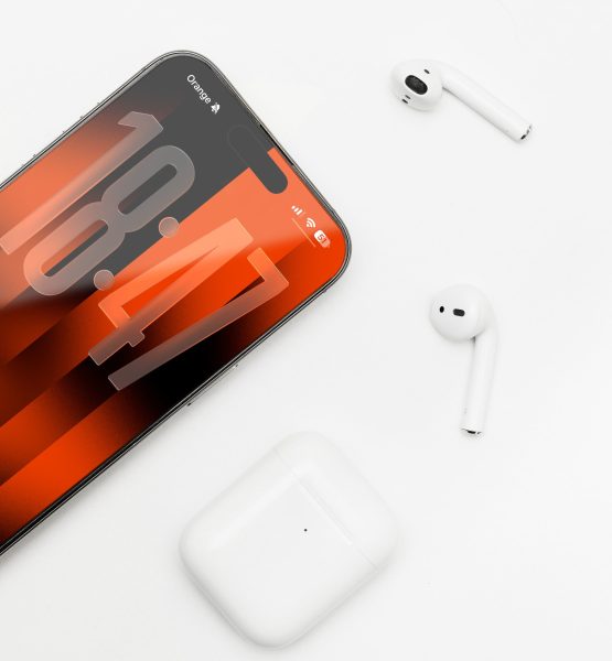 Ein iPhone 17 liegt auf einem weißen Untergrund, darum verteilt sind Air Pods und eine Air Pod Case.