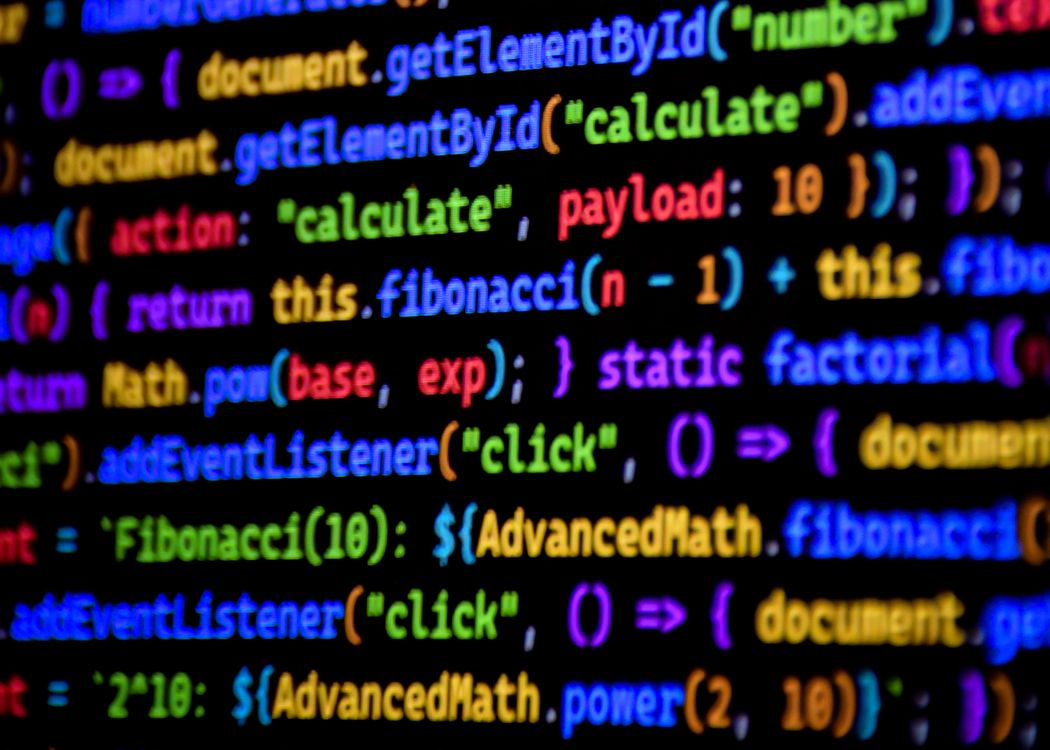 Nahaufnahme eines Bildschirms mit farbig syntaxhervorgehobenem JavaScript-Code auf schwarzem Hintergrund. Sichtbare Funktionen umfassen DOM-Zugriffe mit getElementById, eine Fibonacci-Rekursion, Math.pow sowie mehrere addEventListener-Aufrufe. Die Schlüsselwörter leuchten in Gelb, Cyan, Orange, Rot und Lila.