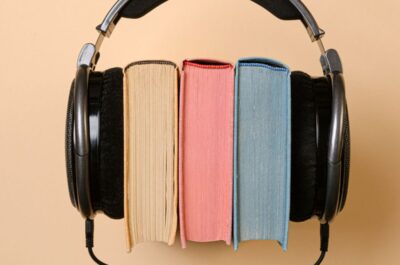 Drei Bücher sind zwischen Kopfhörer geklemmt.