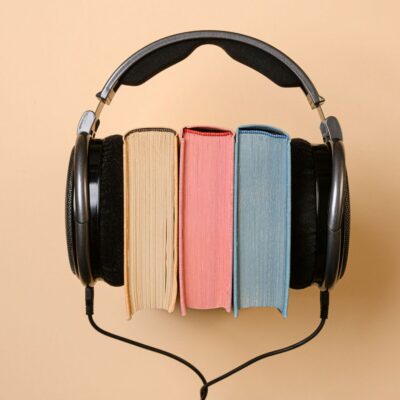 Drei Bücher sind zwischen Kopfhörer geklemmt.