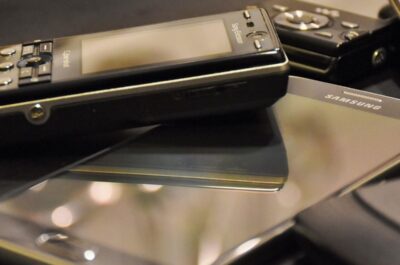 Verschiedene ältere Telefon-Modelle die auf einem schlichten Untergrund liegen.